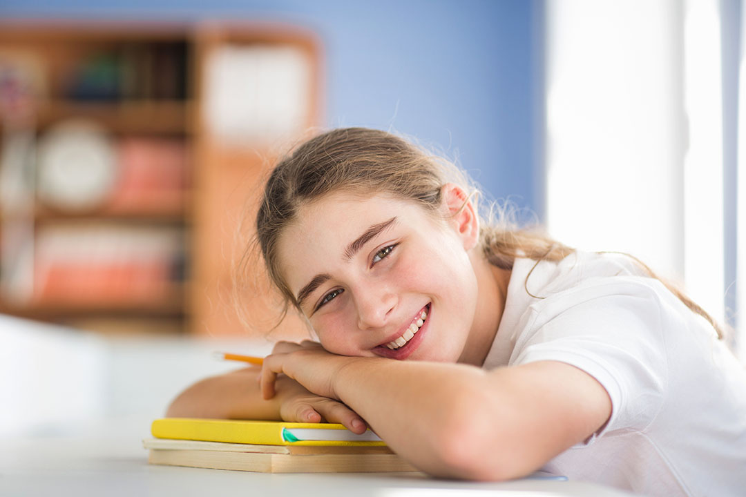 Schülerin lacht in die Kamera